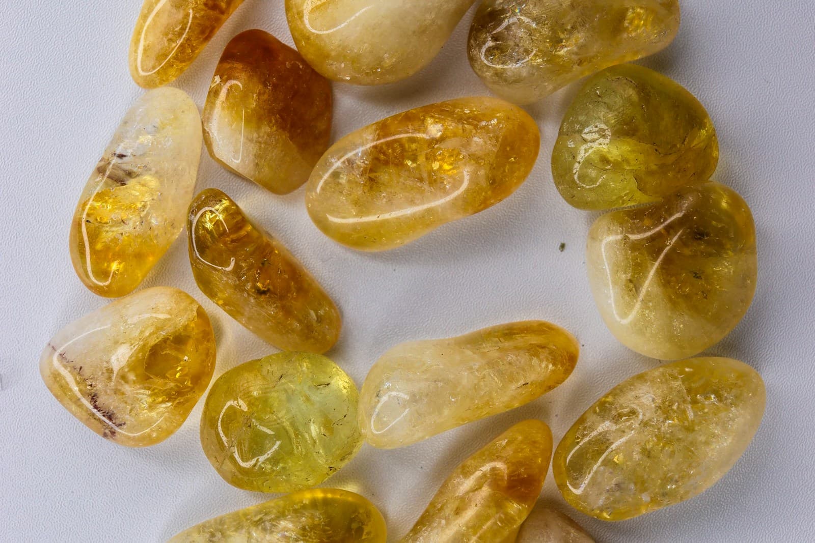 Close-up of tumbled natural citrine stones in shades of yellow and amber